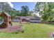 Beautiful backyard featuring a deck, play area, and lush green lawn, perfect for outdoor living at 1588 Peachtree Cir, Lawrenceville, GA 30043