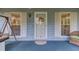 Close-up of the front door, featuring decorative wreath, sidelight windows with shutters, and covered porch at 1588 Peachtree Cir, Lawrenceville, GA 30043