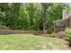 Spacious backyard with mature trees, a wooden fence, and a screened porch off the back of the home at 4445 Ansley Ln, Cumming, GA 30040