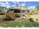 Expansive backyard view showcasing a spacious deck, covered patio, stone landscape, and lush lawn at 4445 Ansley Ln, Cumming, GA 30040