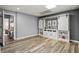 Finished basement area featuring stylish wood flooring and a custom bar area with sliding barn doors at 4445 Ansley Ln, Cumming, GA 30040