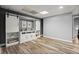 Finished basement with a custom bar area, white sliding doors, and wood flooring at 4445 Ansley Ln, Cumming, GA 30040