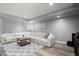 Cozy basement seating area with a sectional sofa, area rug and a stylish coffee table at 4445 Ansley Ln, Cumming, GA 30040