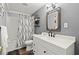 Modern bathroom featuring updated vanity, stylish mirror, and a shower with a patterned curtain at 4445 Ansley Ln, Cumming, GA 30040