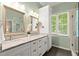 Bathroom featuring double sinks, marble countertops, and a glass shower at 4445 Ansley Ln, Cumming, GA 30040
