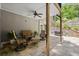 Covered patio with stone flooring, wooden columns, ceiling fan, stone wall and comfortable seating arrangement at 4445 Ansley Ln, Cumming, GA 30040
