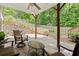 Relaxing outdoor patio features stone flooring, stylish furniture, a ceiling fan, and a wooded backyard view at 4445 Ansley Ln, Cumming, GA 30040