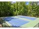 Community tennis courts featuring two blue and green courts surrounded by a wooded area at 4445 Ansley Ln, Cumming, GA 30040