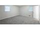 This bedroom features neutral walls, plush gray carpet, and natural light from two windows at 5964 W Fayetteville Rd, Atlanta, GA 30349