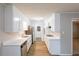 Well-lit kitchen featuring modern appliances, white cabinets, and new countertops at 5964 W Fayetteville Rd, Atlanta, GA 30349