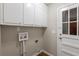 A practical laundry room featuring upper cabinets and access door, perfect for streamlining chores at 5964 W Fayetteville Rd, Atlanta, GA 30349