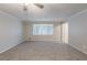 Large living room with carpet, a ceiling fan, and a large window for natural light at 5964 W Fayetteville Rd, Atlanta, GA 30349