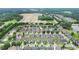 Aerial photo of a neighborhood showcasing the houses with a lake and trees at 663 Warm Springs Ct, Loganville, GA 30052