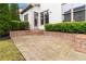 This backyard has a brick patio and landscaped bushes and trees for a relaxing outdoor space at 663 Warm Springs Ct, Loganville, GA 30052