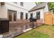 The backyard features a brick patio with space for grilling and a grassy area for outdoor activities at 663 Warm Springs Ct, Loganville, GA 30052