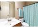 Well-lit bathroom with a vanity, toilet, and shower featuring a stylish blue patterned curtain at 663 Warm Springs Ct, Loganville, GA 30052