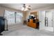 Carpeted bedroom with window, ceiling fan, dresser, and attached bathroom at 663 Warm Springs Ct, Loganville, GA 30052