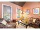 Cozy living room featuring stylish furniture, large windows with blinds, and a warm, inviting ambiance at 663 Warm Springs Ct, Loganville, GA 30052