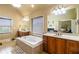 Main bathroom with double sink vanity, tub, and window at 663 Warm Springs Ct, Loganville, GA 30052