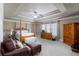 Spacious main bedroom with tray ceilings, wood furniture, sitting area, and neutral carpet at 663 Warm Springs Ct, Loganville, GA 30052