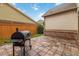Outdoor backyard tiled patio area featuring a stainless steel gas grill and wooden privacy fence at 663 Warm Springs Ct, Loganville, GA 30052