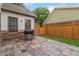 Tiled backyard patio featuring a stainless steel gas grill, wooden privacy fence, and lush landscaping at 663 Warm Springs Ct, Loganville, GA 30052
