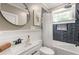 Cozy bathroom featuring modern fixtures, including a round mirror, stylish vanity, and bathtub with shower at 23 Clifton Ne St, Atlanta, GA 30317