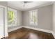 Bedroom featuring neutral wall paint, two windows with natural light, and dark hardwood flooring at 23 Clifton Ne St, Atlanta, GA 30317