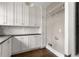 Bright laundry room with white cabinets, dark countertops, and hardwood floors at 23 Clifton Ne St, Atlanta, GA 30317