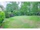 Expansive backyard features lush green grass and mature trees, offering a serene outdoor space at 2592 Dresden Dr, Atlanta, GA 30341