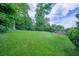 Spacious backyard with lush green lawn, bordered by mature trees and a wooden fence at 2592 Dresden Dr, Atlanta, GA 30341