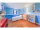 Bright blue bedroom featuring hardwood floors, a ceiling fan, and ample shelving at 2592 Dresden Dr, Atlanta, GA 30341