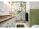Bathroom with dinosaur-themed shower curtain, white and green tiling and brown wood countertop at 5357 Highway 81, Loganville, GA 30052
