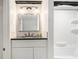 Bathroom vanity featuring a black countertop, undermount sink, framed mirror and decorative patterned backsplash at 5357 Highway 81, Loganville, GA 30052