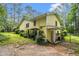 Charming yellow house with lush landscaping and a side entrance, surrounded by tall trees and greenery at 5357 Highway 81, Loganville, GA 30052