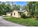 A yellow house on a lush green lawn, featuring an outbuilding to the side of the residence at 5357 Highway 81, Loganville, GA 30052