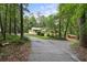 Scenic shot of a yellow home nestled among tall trees, showcasing a private driveway and natural landscape at 5357 Highway 81, Loganville, GA 30052