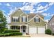 Charming two-story home featuring a welcoming porch, two-car garage, and well-maintained landscaping at 216 Toonigh Way, Canton, GA 30115
