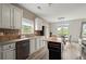 Bright kitchen with white cabinets, stainless appliances, and eat-in dining area at 216 Toonigh Way, Canton, GA 30115