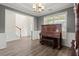 Bright living room boasts gorgeous floors, a piano, and ample natural light at 216 Toonigh Way, Canton, GA 30115