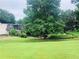 Expansive backyard with lush green grass, mature trees and view of home exterior at 2805 Ne Expressway Unit A24, Atlanta, GA 30345