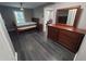 Open bedroom with dark wood floors, a ceiling fan, a bed, and a dresser with a mirror at 2805 Ne Expressway Unit A24, Atlanta, GA 30345