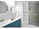 Bathroom featuring a double sink vanity, a round mirror, and a glass-enclosed shower at 2928 George Busbee Pkwy, Kennesaw, GA 30144
