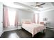 Bright bedroom features a tray ceiling, dark wood floors, and windows dressed with pink curtains at 2928 George Busbee Pkwy, Kennesaw, GA 30144