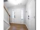 Bright entryway featuring hardwood floors, a white front door flanked by windows, and staircase with white railing at 2928 George Busbee Pkwy, Kennesaw, GA 30144