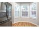 Bright kitchen nook with stainless steel refrigerator, hardwood floors, and multiple windows at 2928 George Busbee Pkwy, Kennesaw, GA 30144