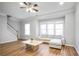 Cozy living room with hardwood floors, large windows, and a ceiling fan at 2928 George Busbee Pkwy, Kennesaw, GA 30144