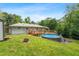 Backyard featuring an above-ground pool, fire pit, and wooden deck at 3153 Bonway Dr, Decatur, GA 30032