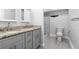 Bathroom with double vanity, granite countertops, gray cabinets, and tiled walk-in shower at 3153 Bonway Dr, Decatur, GA 30032