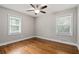 Bedroom with hardwood floors, ceiling fan, two windows, and neutral colored paint at 3153 Bonway Dr, Decatur, GA 30032